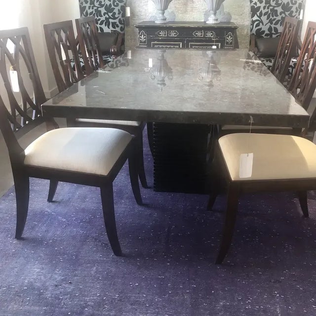 Contemporary dining table featuring a fossilized desert stone top, and the base is solid wood with a ebonized matte...