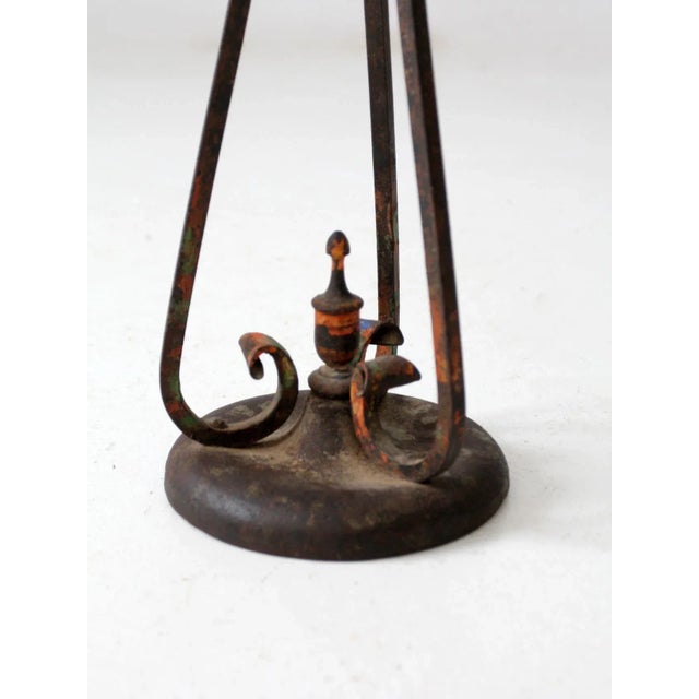 This is an antique cast iron standing ashtray. The decorative ashtray stand features a floral motif base with painted...