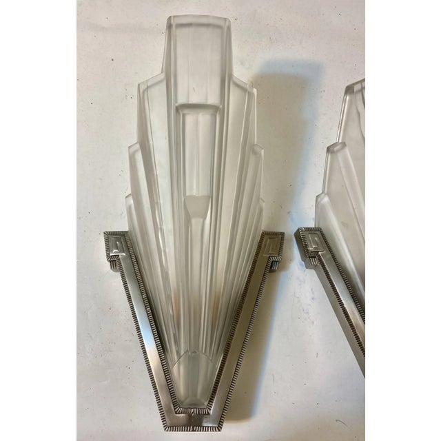 Pair of French Art Deco sconces by the famous French artist "Marius Ernest SABINO". The shades are clear frosted glass...