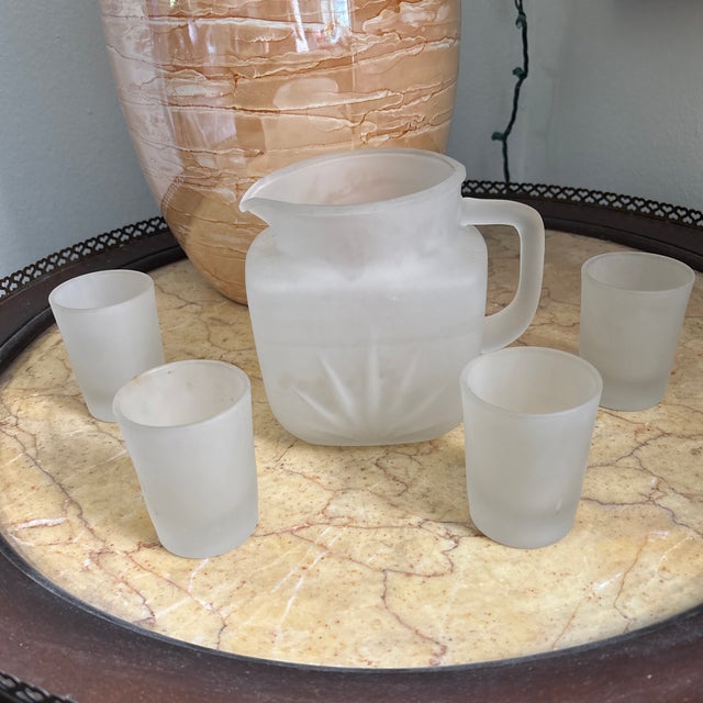 This charming 1950s frosted glass set contains a pitcher and four small juice glasses. A pretty antique addition to your...