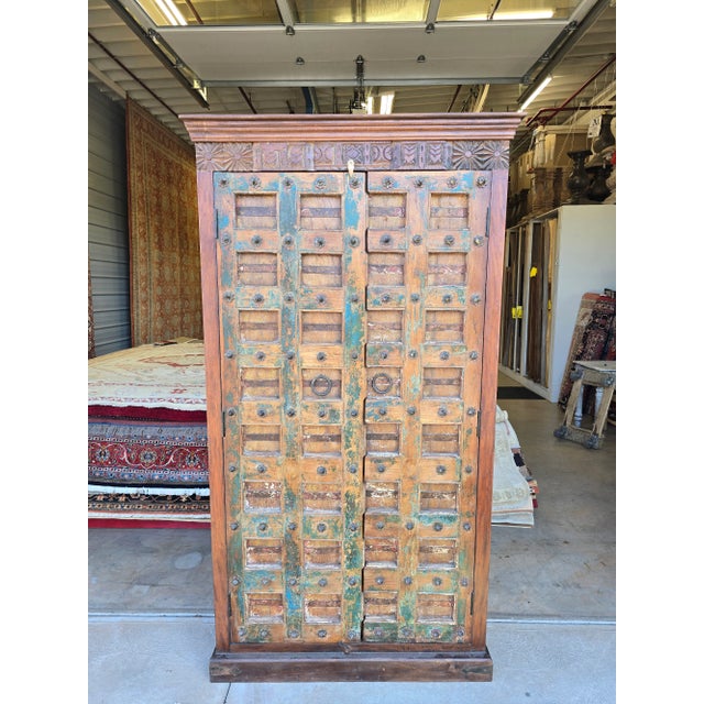 This Reclaimed wood Cabinet with antique slab doors, features a checked pattern on the multicolor doors, made from iron...