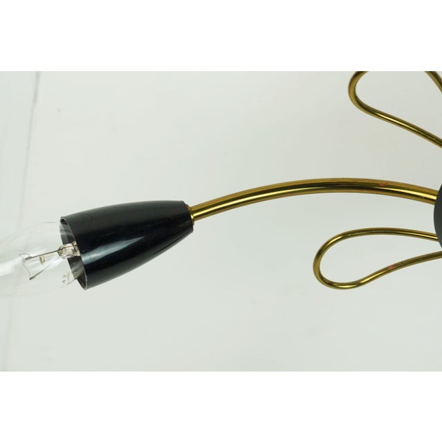 Beautiful Sputnik ceiling light from the 1950s. It is made of brass with black accents. It features a total of five arms...