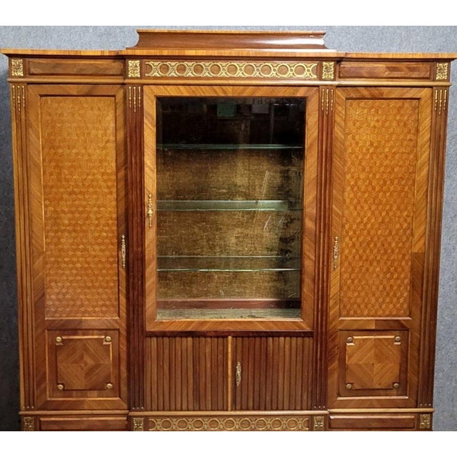An important display cabinet in fine woods and marquetry, stamped a. Bastet, lyon, remarkable for the richness of its...