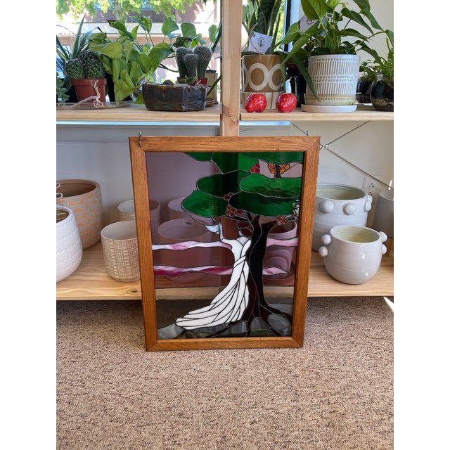 Vintage stained glass art panel featuring a serene and romantic scene of a woman in a long, flowing white gown standing...