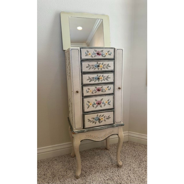 Beautiful hand-painted floral jewelry armoire with elegant cabriole legs and distressed finish.Features a lift-top mirror,...