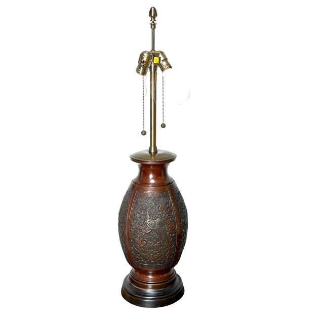 This is a fabulous mid-century cast bronze table lamp featuring Asian inspired pictoral reliefs of peacocks, florals and...