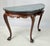Chippendale-style demilune console table featuring a richly veined, fitted dark green marble top. The carved wood frame...