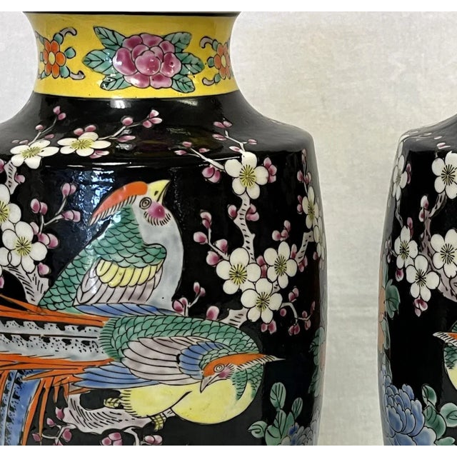 Stunning pair of Chinoiserie style hand painted porcelain vases. The classic vases depict birds and peonies in shades of...