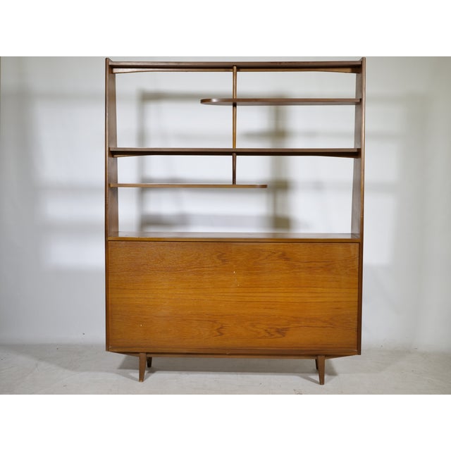 Mid-century teak highboard with an open shelving unit, 1960s. The lower section offers storage behind two sliding doors...