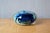 This small, flat, spherical bottle is made of blown glass. Its predominantly blue decoration is rich with multicolored and...