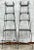 Crafted with an airy, vertical presence, this pair of vintage 20th-century metal étagères features graceful Victorian-...