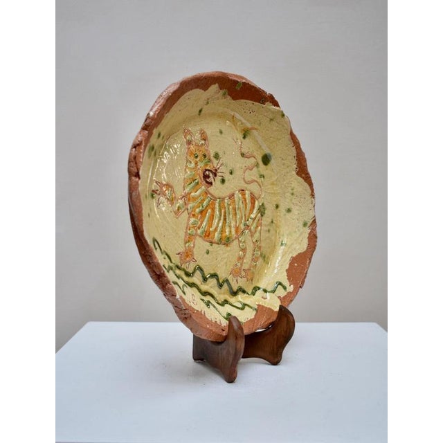 This decorative earthenware plate by Ben Fosker features a slip-decorated depiction of a tiger. The piece balances folk...