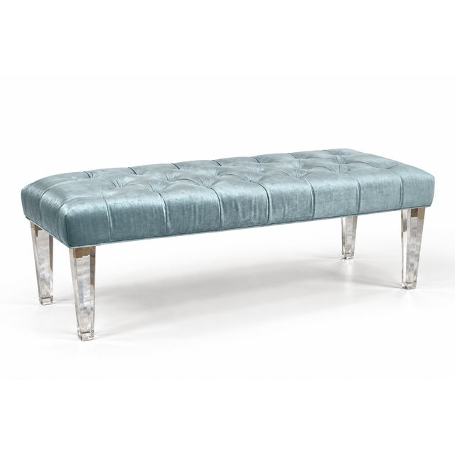 A refined contemporary bench featuring a clean, architectural silhouette softened by deep button tufting. The elongated...