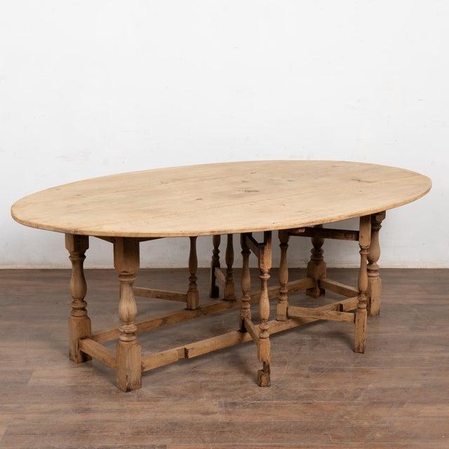 20th-century English wake table crafted in bleached oak with classic dropleaf construction. Gateleg supports allow...