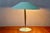 This table lamp with its distinctive silhouette is model 6767 from the German firm Kaiser Idell (Kaiser Leuchten). With...