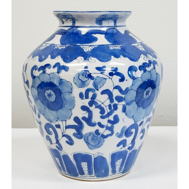 Vintage Asian porcelain jar with vibrant blue and white floral motif throughout. Age wear. No chips or cracks.