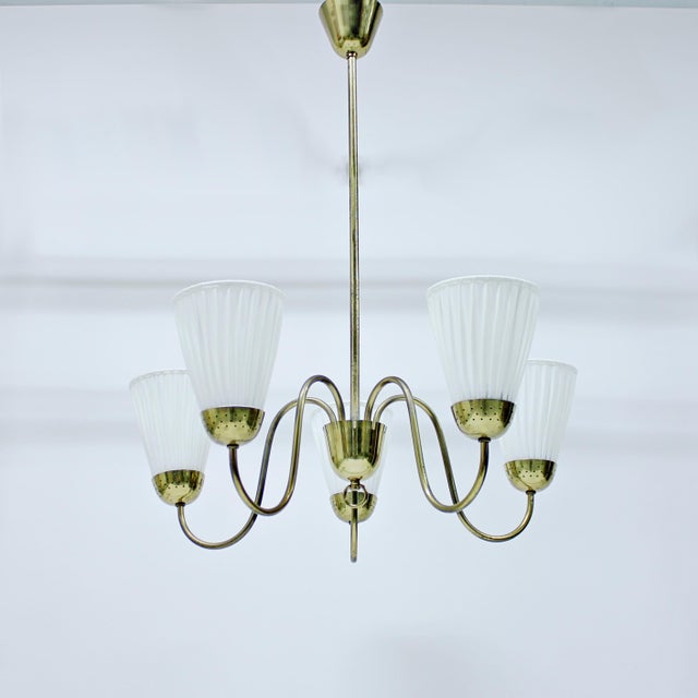 Swedish Modern, 5-light brass chandelier with with uplight shades attributed to Bergboms. The uplight shades are mounted...