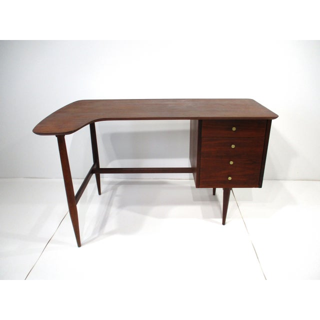 A sculptural and very functional walnut writing desk with boomerang styled top , upper smaller drawer and lower file...
