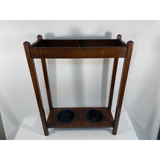 A fine and sturdy Mission Style Oak Umbrella Stand with metal drip cups. Circa 1880-1920s. This handsome umbrella stand...