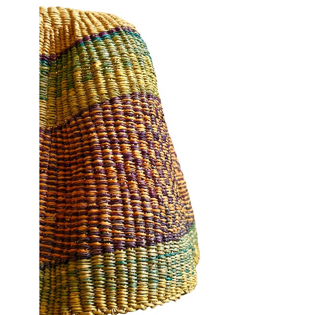 This pendant light began as a traditional Bolga basket from northern Ghana. These baskets were objects of daily use, woven...