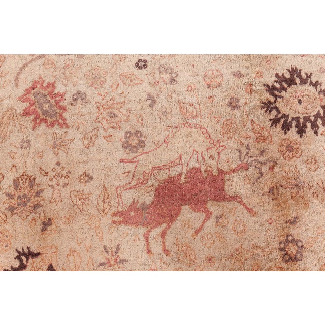 A Turkish Sivas carpet, having a beige field with scattered animals, palmettes and floral motifs around a cinnamon cusped...