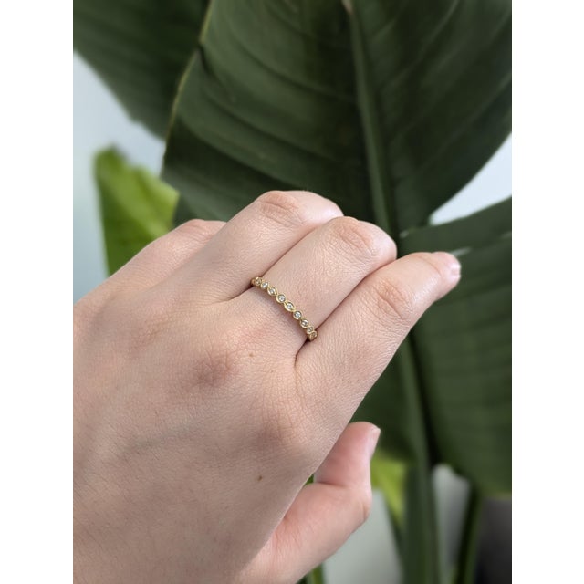 Delicate and refined, this stackable band in solid 14K yellow gold features earth-mined diamonds framed with vintage-...