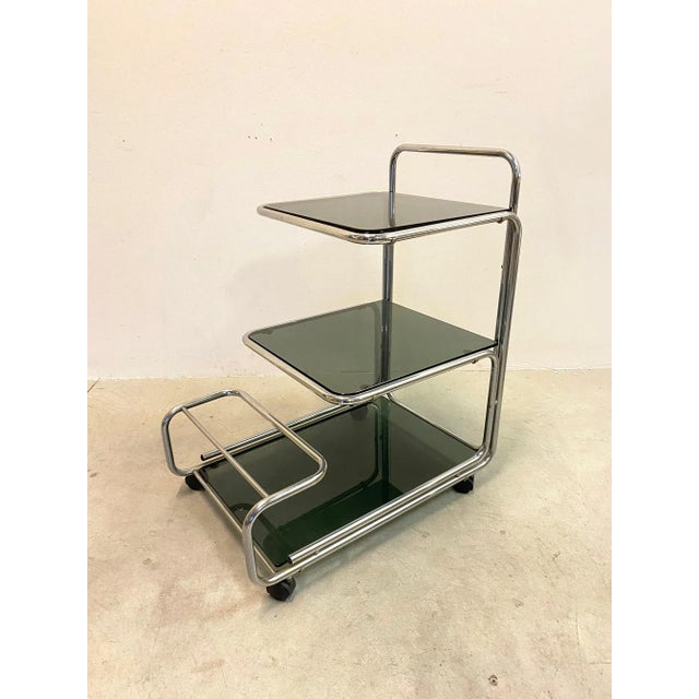 Bar trolley 70's, chromed steel structure and three shelves in smoked glass.