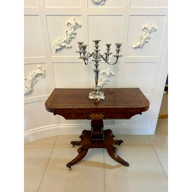 A fine antique English mahogany fold-over table dating from the Regency period, designed to function both as a console...