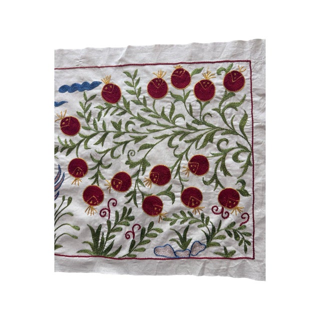 Hand-embroidered Suzani panel from Uzbekistan, worked in fine floss on a cream cotton ground. Two winged horses move...
