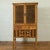 An antique Indonesian kitchen cabinet from the early 20th century, with fretwork sliding doors, drawers and rattan...