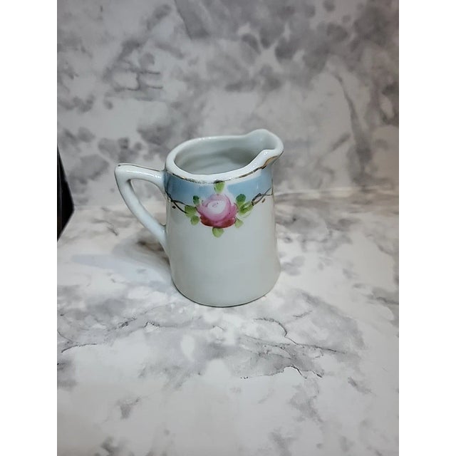 This beautiful Nippon creamer is made of porcelain, handpainted and has a gold trim. Marked Japan and features a charming...