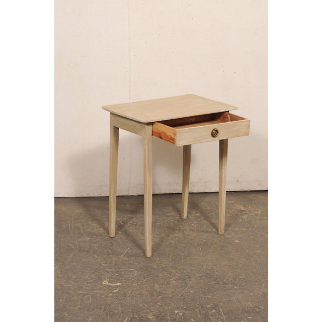 A Swedish painted wood side table with drawer from the early 20th century. This antique table from Sweden has been...