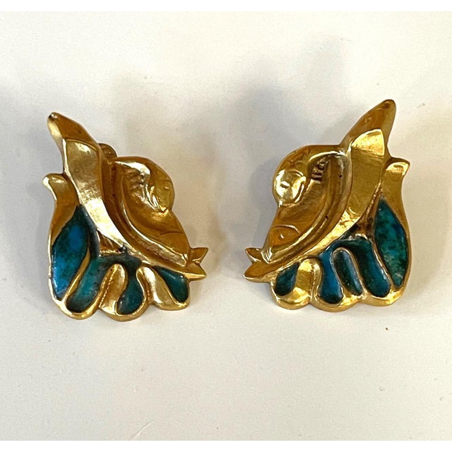 A pair of bespoken earrings by French Art Jeweler Line Vautrin (1913-1997). The cast bronze earring features a sculptural...