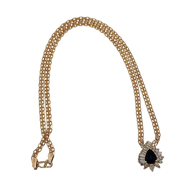 Estate pear sapphire & diamond 14 karat gold pendant necklace. At the center of this regal pendant, you will find a 1.5...