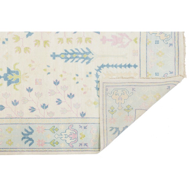 Elevate your space with this hand-knotted Oushak-style rug, showcasing a contemporary twist on traditional Turkish motifs....