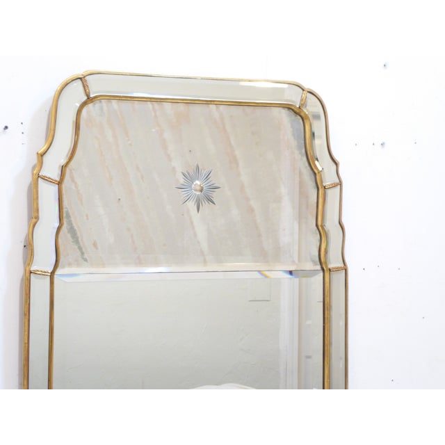 This mid century mirror with the Queen Anne shape, has a beveled mirror outer frame with gilt-wood edging, the split...