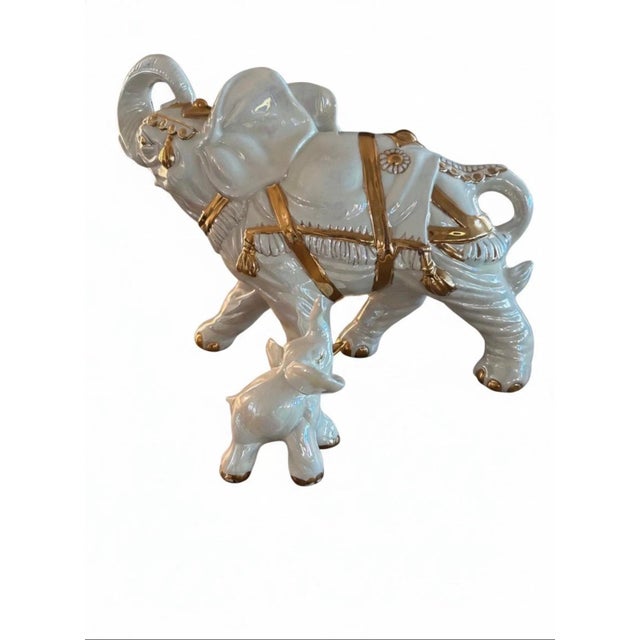 This elegant set of two porcelain elephant figurines features a larger and a smaller elephant, both adorned with intricate...