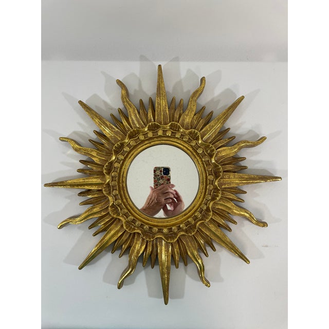 A celestial French Style Gilded Resin Sunburst Wall Mirror from the 1960s. This fabulous 17.25" wall mirror features...
