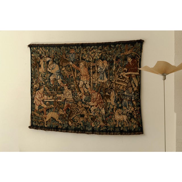 Wall tapestry produced in France. Woodcutters at work in a medieval setting. In good condition.