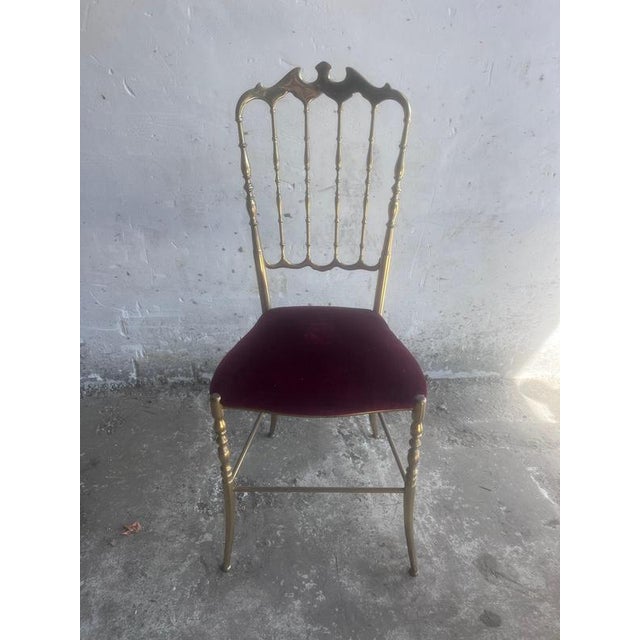 Elegant vintage Chiavari-style chair dating from the 1970s. The slender brass frame features an ornate openwork backrest...