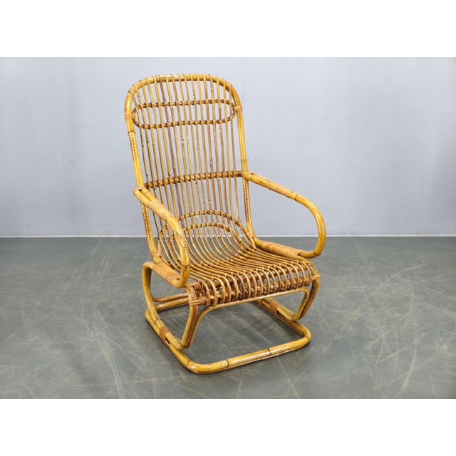 Elegant Mid Century rattan lounge armchair produced in Italy during the 1960s. This beautifully crafted vintage chair...