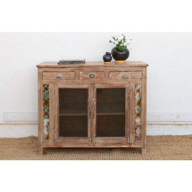 This 44-inch wide buffet is a standout piece of British Colonial craftsmanship, featuring a rare whitewashed teak frame....