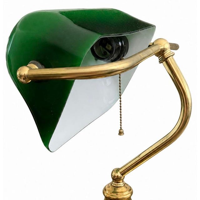 Vintage brass banker’s desk lamp with an emerald green glass shade and polished brass finish. A classic statement piece...