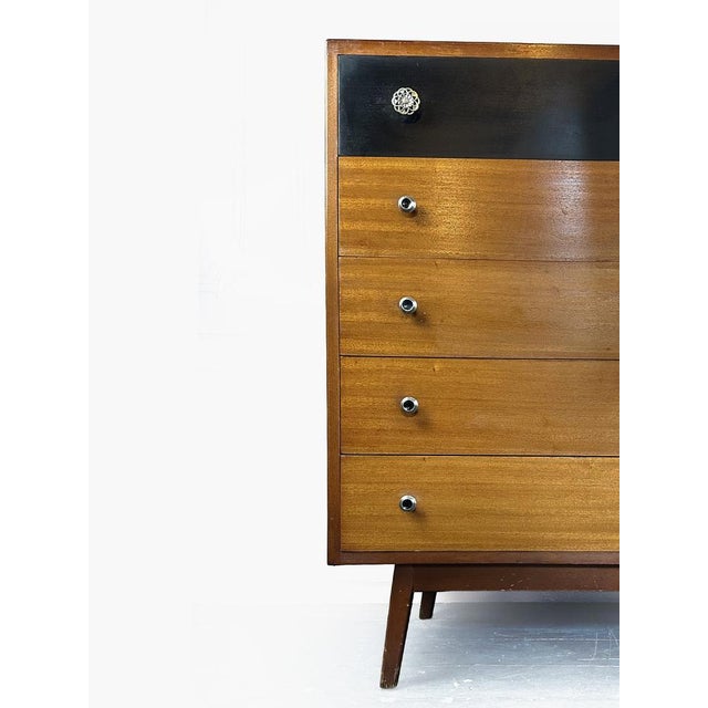 A well-proportioned and characterful example of mid-century British domestic furniture, this five-drawer tallboy was...