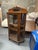 An American antique oak wood and glass curio display cabinet with decorative woo detailing and a mirrored toppediment. The...