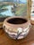 This vintage hand-painted terracotta pot features a vibrant desert landscape rendered in rich, earthy tones. The scene...