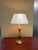 A finely detailed Neoclassical table lamp crafted entirely from solid brass. The base features ornate classical detailing...