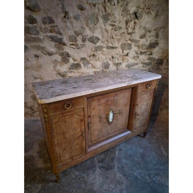 Louis XVI style cabinet dating from the late 19th century, constructed from oak and mahogany with burr elm veneer. The...