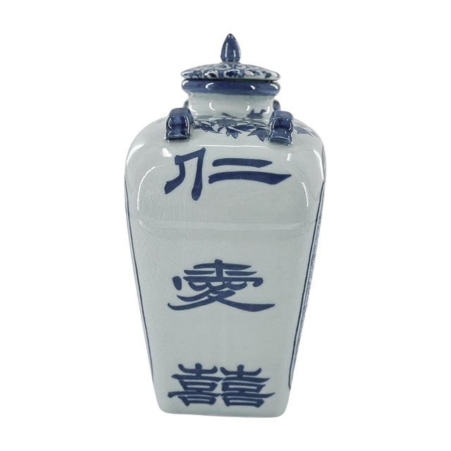 A blue and white porcelain temple jar featuring a spirited dragon framed by stylized clouds and an intricate scrolling...