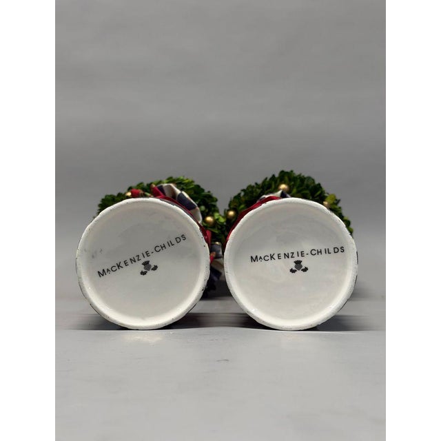 Formal garden silhouettes meet MacKenzie-Childs’ distinctive decorative style in this coordinating pair of tabletop...